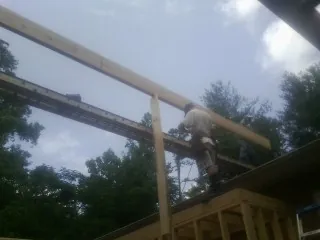 Carpenter setting a ridge beam over a new addition frame — Ice Dam Removal by Roofing Brothers in Laverne