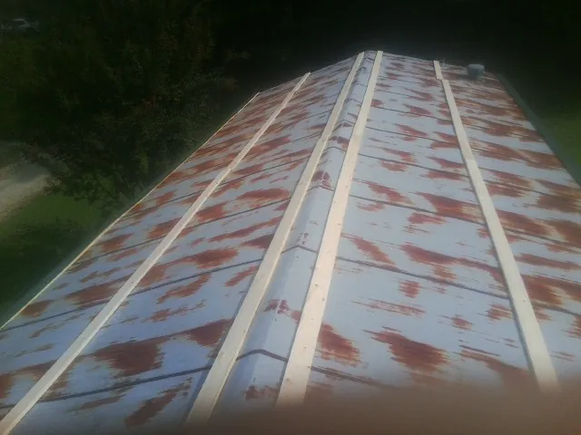 Rusted metal roof panels with new wood purlins before replacement — Storm Damage Roof Repair in Laverne by Roofing Brothers