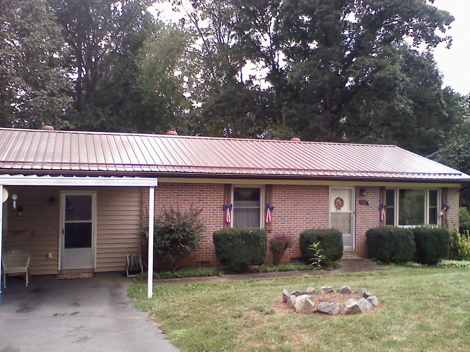 Bronze metal roof and carport on a brick ranch home — Roof Repair work by our crew in Laverne