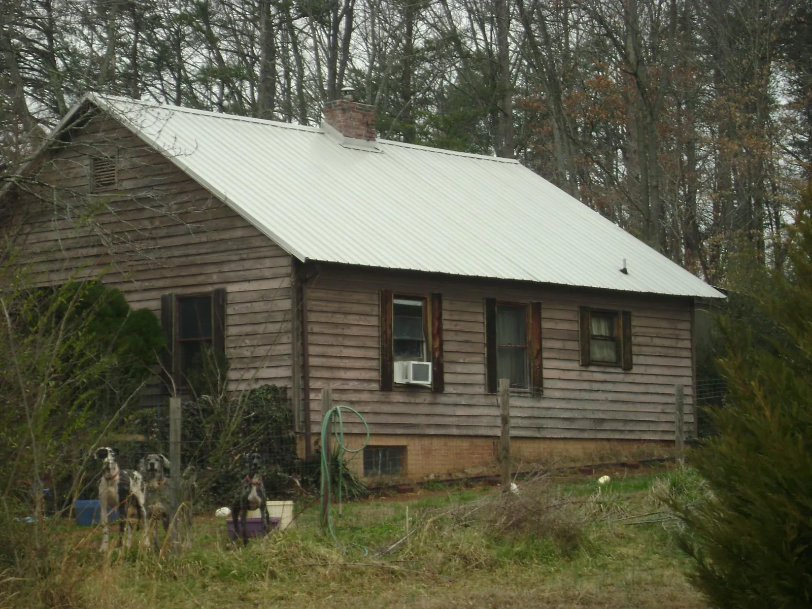 White metal roof on an old wood sided farmhouse, from a Metal Roof Installation job in Laverne